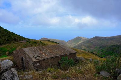 Scenic view of mountain against cloudy sky