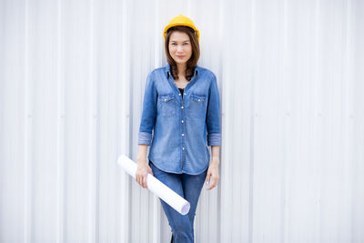 Portrait of beautiful woman standing against wall