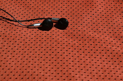 Close-up of in-ear headphones on textile
