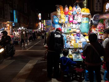 Rear view of people standing at market