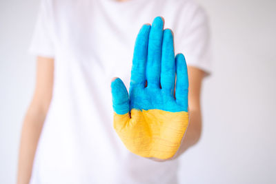 Woman's hand is painted in yellow-blue flag of ukraine. stop the war. russia ukraine war. peace .