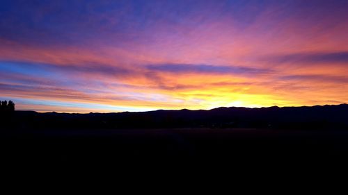 Silhouette of landscape against sky at sunset