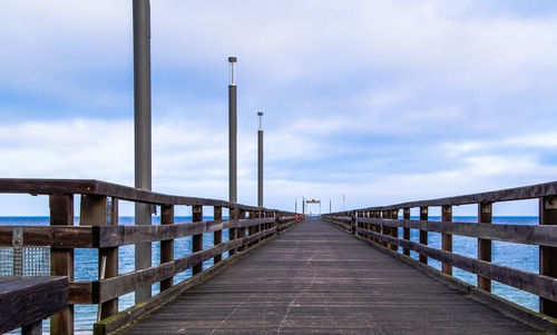 Footbridge over pier against sky