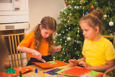 Mother and girl in illuminated christmas tree