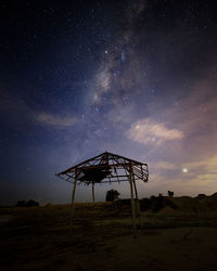 Windmill on field against sky at night