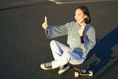 Portrait of young woman standing on road