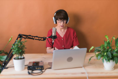 Senior woman podcasting in studio