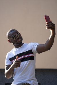 Man with sunglasses using mobile cell phone.