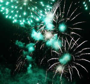 Low angle view of firework display at night