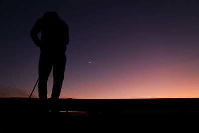 Silhouette man standing against sky during sunset