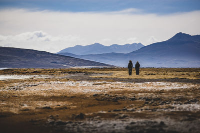 People on mountain against sky