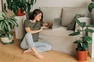 Portrait of young woman sitting on sofa at home