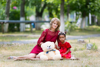 Portrait of mother and daughter sitting in park