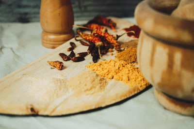 Spices by mortar and pestle on table