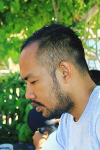 Close-up portrait of young man looking away outdoors