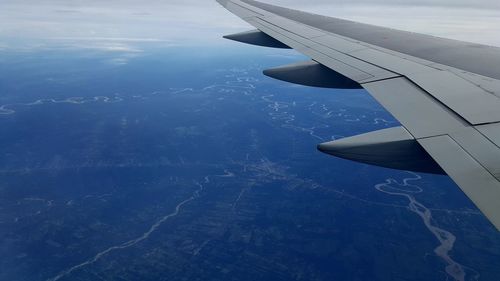 Aerial view of airplane wing over landscape