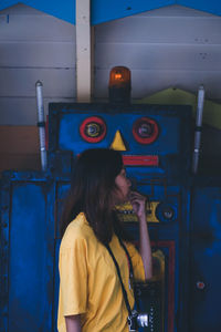 Side view of woman looking away while standing by robot