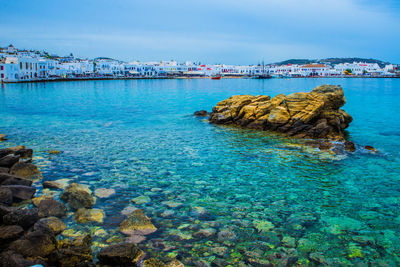 Scenic view of rocks in sea against sky