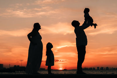 Silhouette couple against sky during sunset