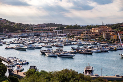 Boats in town against cloudy sky