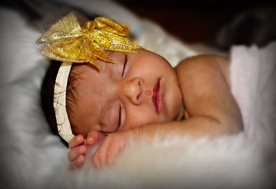 Close-up of baby sleeping in bed