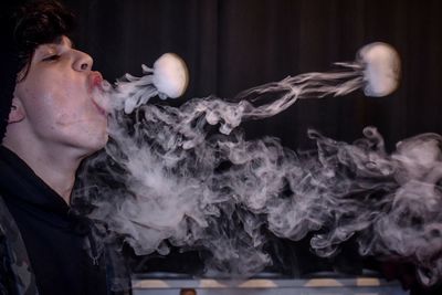 Close-up of young man exhaling smoke