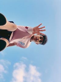 Low angle view of woman against blue sky