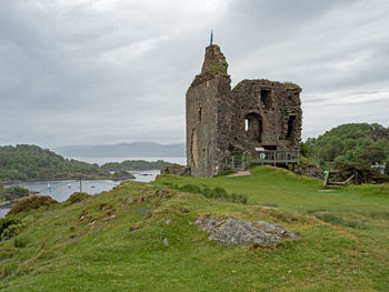 Tarbert castle ruins on a hill with a view of east loch tarbert and hills, argyll, scotland