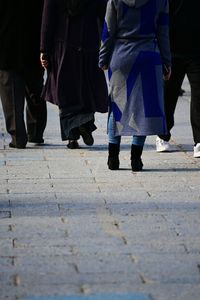 Low section of people walking on zebra crossing