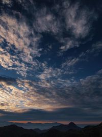 Low angle view of silhouette mountains against dramatic sky