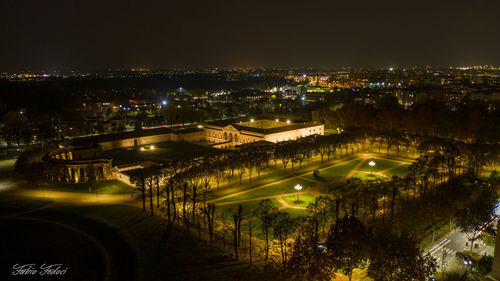 High angle view of illuminated city by river at night