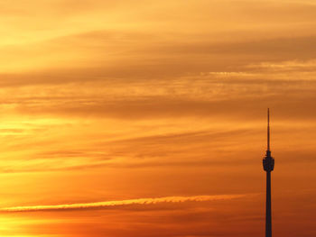 Communications tower against sky during sunset