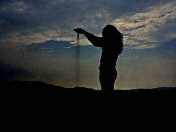 Silhouette people standing against sky at sunset