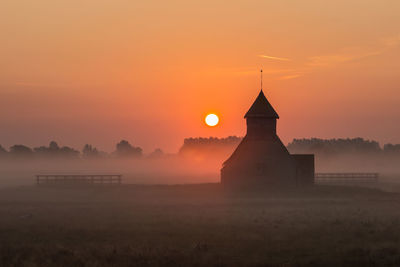 Church on field against sky during sunset