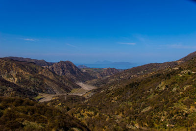 Scenic view of mountains against blue sky