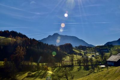 Scenic view of landscape in autumn against mountain and sky