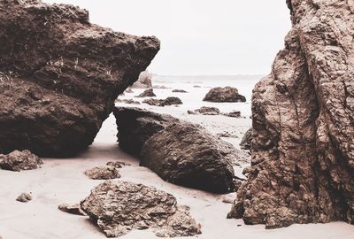 Rocks on beach against clear sky