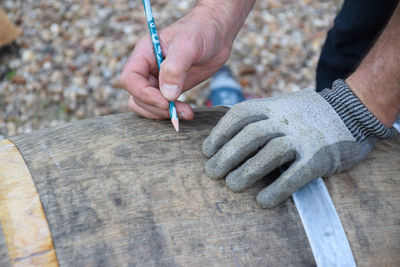 Cropped image of worker working on wood with tools