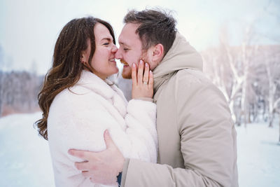 Loving couple on a snowy winter field. happy together.