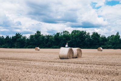 Hay bales on field against sky