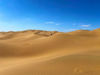 Scenic view of desert against blue sky