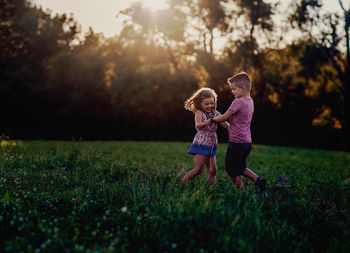 Siblings on grassy field