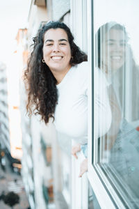 Portrait of smiling young woman standing in city