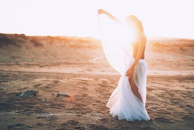 Woman on sand at beach against clear sky