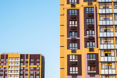 High-rise residential buildings with colorful facades during sunset.