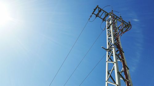 Low angle view of power lines against blue sky