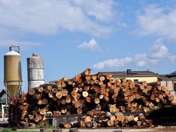 Stack of logs against sky