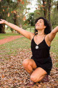 Young woman standing on field during autumn