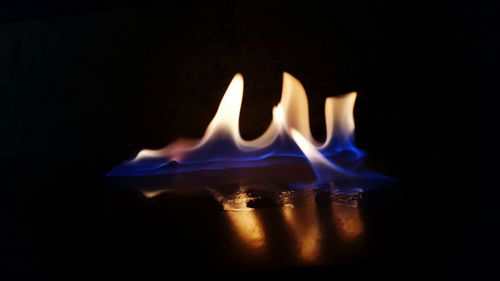 Close-up of burning candle in darkroom