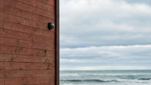 Close-up of stone wall by sea against sky